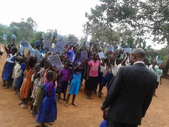 A group of children gather for community service outdoors