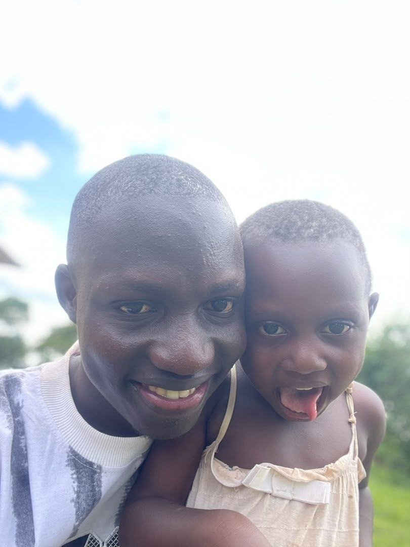 Healthcare worker smiles with two children outside a clinic