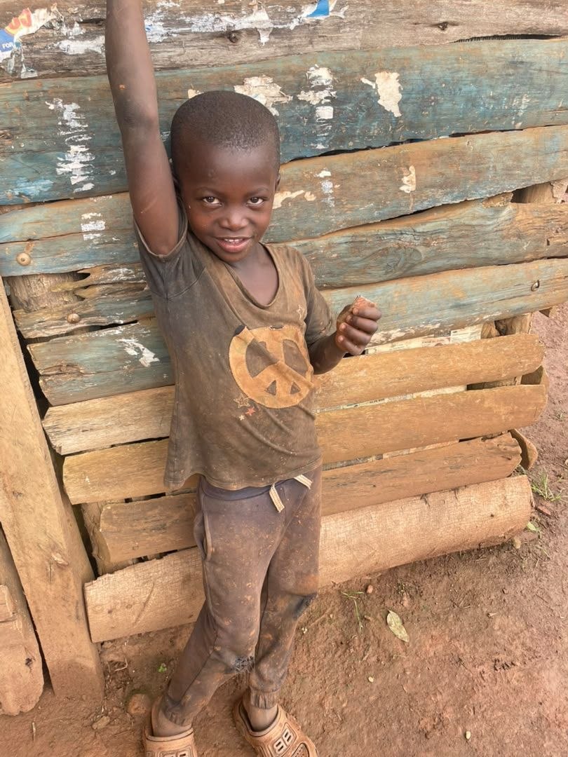 Portrait of a young boy holding a book outdoors